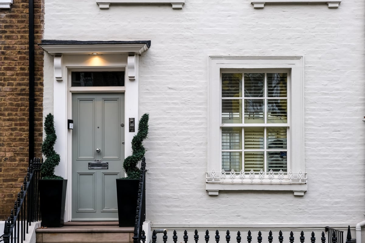 London, UK – A sophisticated grey front door on a white terraced house in Chelsea